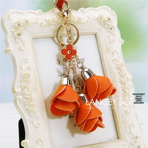 Detail of orange floral leather keychain with lychee texture and golden ring