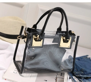 Detailed shot of transparent PVC tote bag with black handles and metal gold hardware