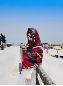 Bohemian floral printed beach shawl draped over shoulders in a scenic seaside highway