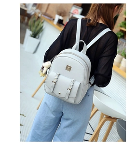 Lifestyle-Foto von hellgrauem Kunstleder-Rucksack mit Blumenband und goldenem Metall-Logo