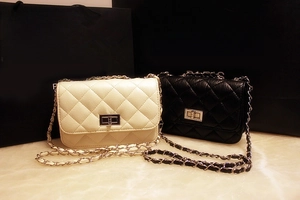 Detail of classic quilted flap bags in black and white with chain straps and metal turn-lock
