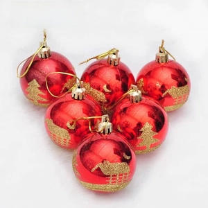 Macro detail of red Christmas ball ornaments with gold glitter tree patterns on fur