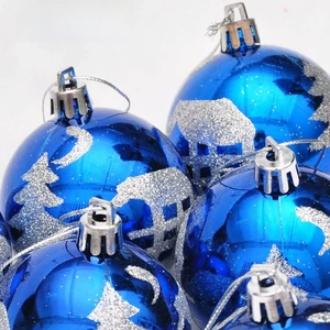 Close-up of blue Christmas ball ornaments with silver glitter forest patterns and hanging loops