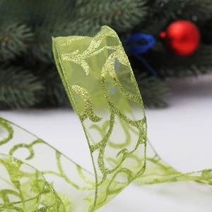 Detail of green sheer organza Christmas ribbon with sparkling glitter vine patterns