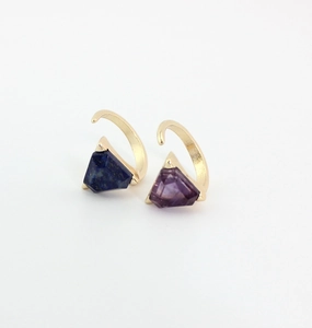 Macro detail of gold rings set with natural amethyst and lapis lazuli stones