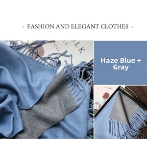 Detail of smog blue and grey double-sided scarf with elegant tassel edges and soft texture