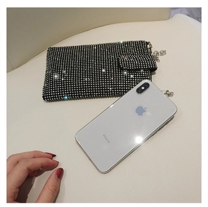 Close-up of sparkling rhinestone phone bag with silver chain strap and snap closure