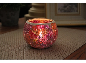 Detail of mosaic glass candle holder with warm glow on wooden table for home decor