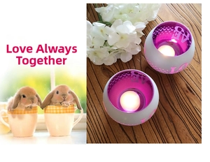 Detail of two purple globe-shaped candle holders with LOVE and heart cutout patterns