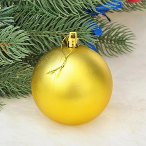 Detail of matte gold Christmas ball ornament with hanging loop and golden string