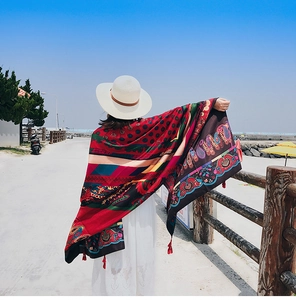 Detailed view of colorful paisley pattern shawl with red tassels for beach travel