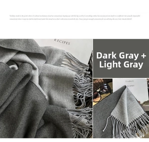 Detail of grey cashmere scarf featuring thick fringed edges and soft warm texture
