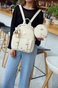 Detail eines cremefarbenen PU-Leder-Rucksacks mit goldener Hardware und Rundtasche