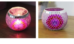Macro detail of mosaic glass candle holder in pink and purple with lit candle light