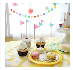 Pink and blue triangle cake toppers on macarons for anniversary party decoration