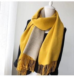Close-up of ginger and oatmeal double-sided thick scarf with long tassel detail