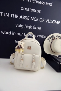 Detail eines cremefarbenen PU-Leder-Minirucksacks mit 3D-Gänseblümchen und Bärchen