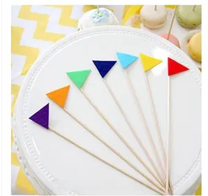 Colorful felt pennant cake toppers arranged on a stand for anniversary party decor