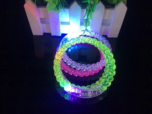 Macro shot of colorful LED acrylic bubble bracelets glowing in dark with power switches