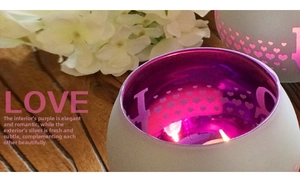 Detail of silver heart cutout glass candle holder with purple interior and LOVE pattern