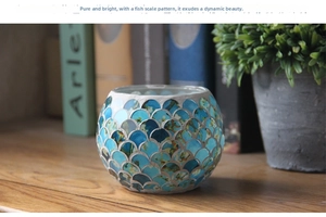 Close-up of blue scale mosaic glass candle holder on a wooden table in home setting