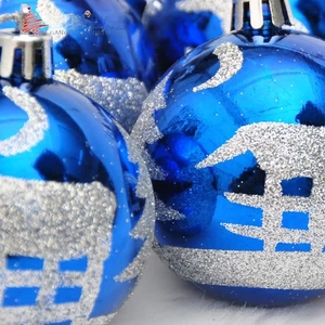 Detailed close-up of royal blue Christmas balls featuring silver snow scene patterns