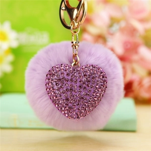 Close-up of purple plush heart keychain with sparkling rhinestones and golden clasp