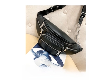Detail of black PU leather waist bag featuring silver zippers and metal chain strap