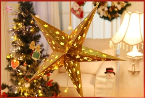 Close-up of golden hollow star lamp with warm glowing interior for Christmas decor