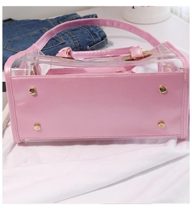 Detail view of pink and transparent jelly beach bag with golden metal hardware and bottom studs