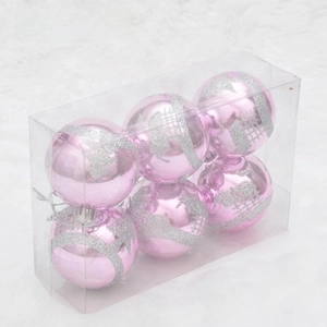 Close-up of six pink Christmas balls with silver glitter patterns in a transparent box