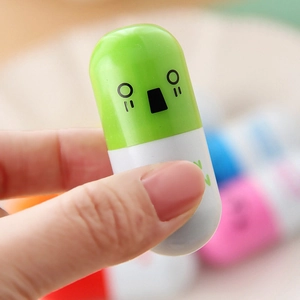 Close-up of a green and white capsule ballpoint pen with a cute cartoon face
