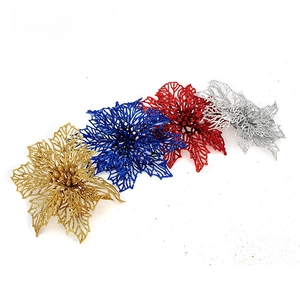 Close-up of sparkling hollowed-out Christmas flowers in gold, blue, red and silver glitter