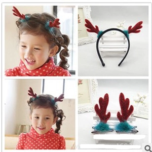Detail of red Christmas reindeer antler headband and hair clips set with green plush accents