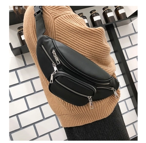 Detail of black PU leather waist bag with multiple silver zippers and adjustable strap