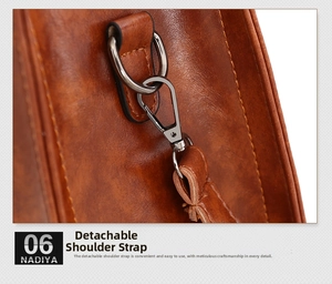 Detail of a brown leather bag showing detachable strap with gunmetal hardware hooks