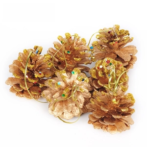 Dettaglio di sei pigne dorate con glitter colorati e cordini per l'albero di Natale