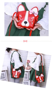 Detail view of red puppy-shaped crossbody bag with white ears and a pink bow