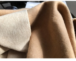 Macro shot of high-quality double-sided cashmere-feel fabric in classic camel and beige