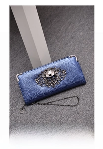 Detail of navy blue punk skull wallet with metallic crinkle texture and floral relief