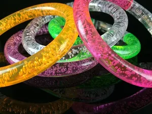 Detailed macro view of colorful acrylic bubble bracelets on a black reflective surface