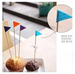 Close-up of colorful felt cake toppers with wooden sticks for anniversary party decoration