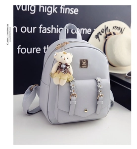 Nahaufnahme hellblauer PU-Rucksack mit Blumenschnalle und Teddybär-Anhänger-Detail