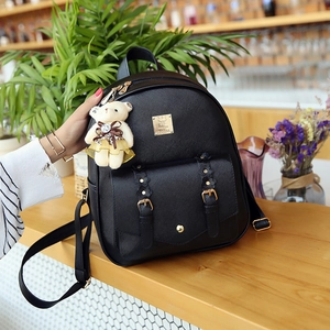 Nahaufnahme des schwarzen PU-Lederrucksacks mit Bärenanhänger und goldenen Blumenschnallen
