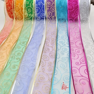 Macro detail of Christmas organza ribbons with glittering swirl patterns in multiple colors