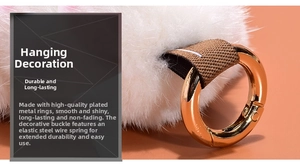 Detail of golden metal clasp and woven strap on a white fluffy rabbit fur keychain
