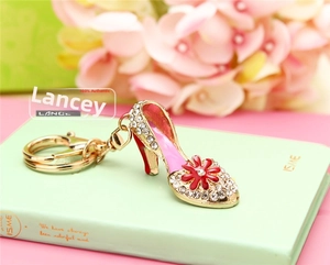Detail of pink enamel high heel keychain with sparkling crystals and red flower accent