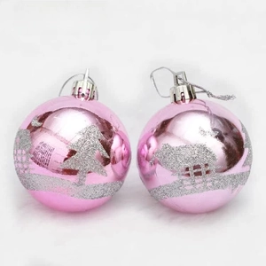 Close-up of pink shiny Christmas balls with silver glitter pine tree and house patterns