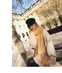 Detail of camel mohair knit scarf with long tassels in a stylish winter street setting