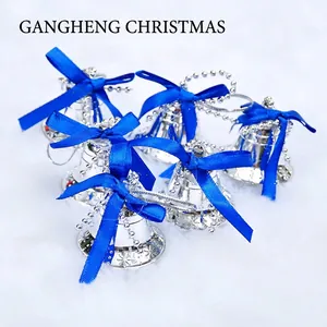 Set of 6 silver Christmas bells with blue bows and snowflake pattern on plush white fabric